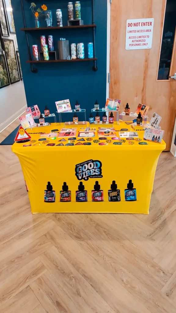 Good Vibes bottles and colorful display cards at Bask Sun Grown Cannabis - Fairhaven.
